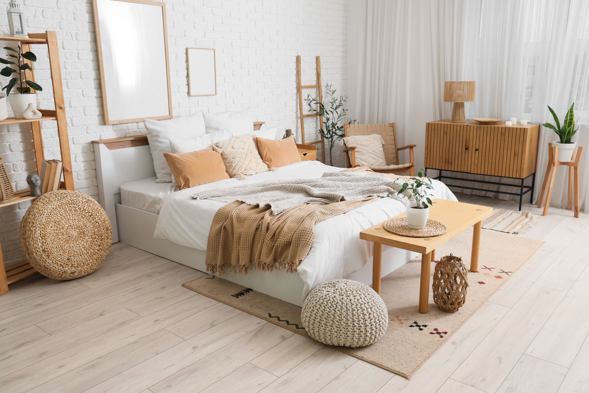 Gemütlich eingerichtetes Schlafzimmer mit hellen Textilien, Holzmöbeln und dekorativen Elementen